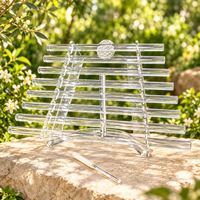 Flower of Life nine-tube clear crystal harp on stone in a sunlit garden