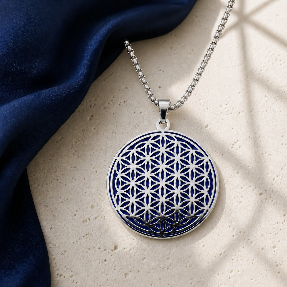 Indigo and silver Flower of Life charm necklace close-up on ivory stone