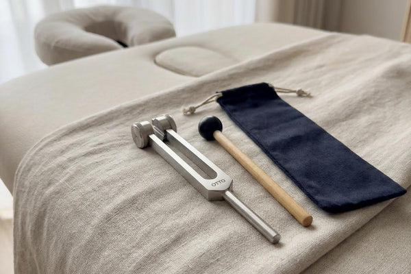 128 Hz OTTO Tuning Fork with drawstring pouch and striker on white background