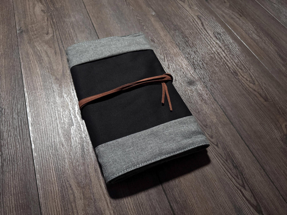 a gray and black notebook on a wooden floor