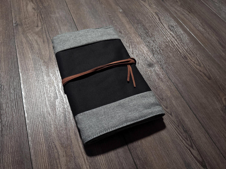 a gray and black notebook on a wooden floor
