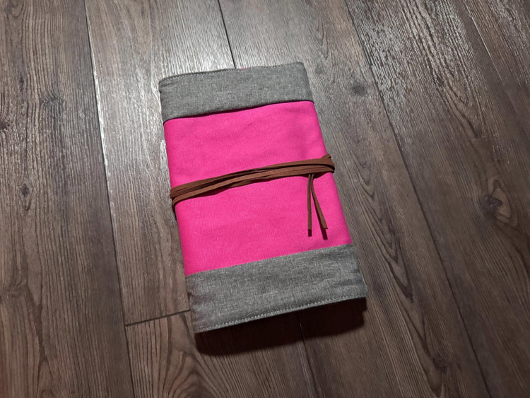 a pink and grey notebook on a wooden floor