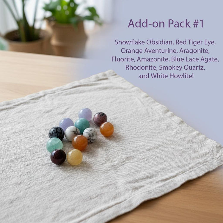 a collection of colorful gemstones, including a snowflake obsidian, a red tiger eye, an orange avanturine, an aragonite, a fluoride, an amethyst, a blue lace agate, a rhodonite, a smoky quartz, and a white howlite.