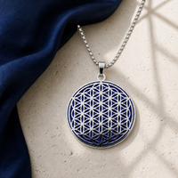 Indigo and silver Flower of Life charm necklace close-up on ivory stone